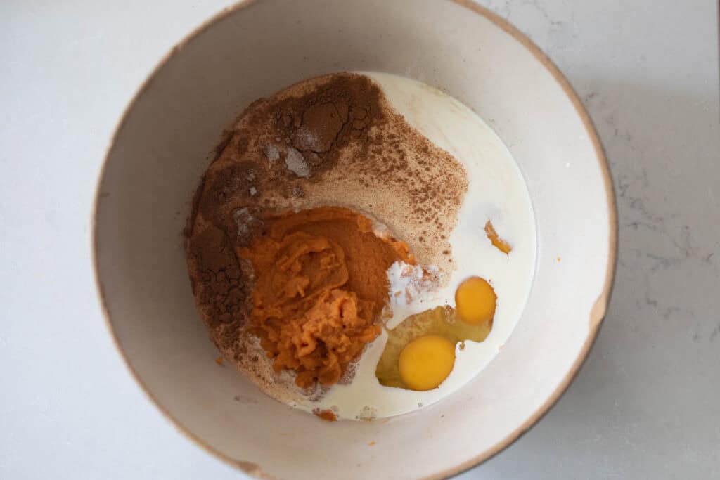 Pumpkin pie ingredients in a bowl ready to be mixed.