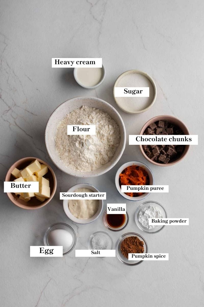 The ingredients for pumpkin scones all out on a countertop in separate bowls.