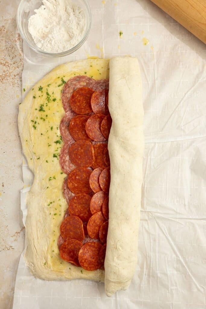 Rolling up a Sourdough Stromboli with a variety of meats.