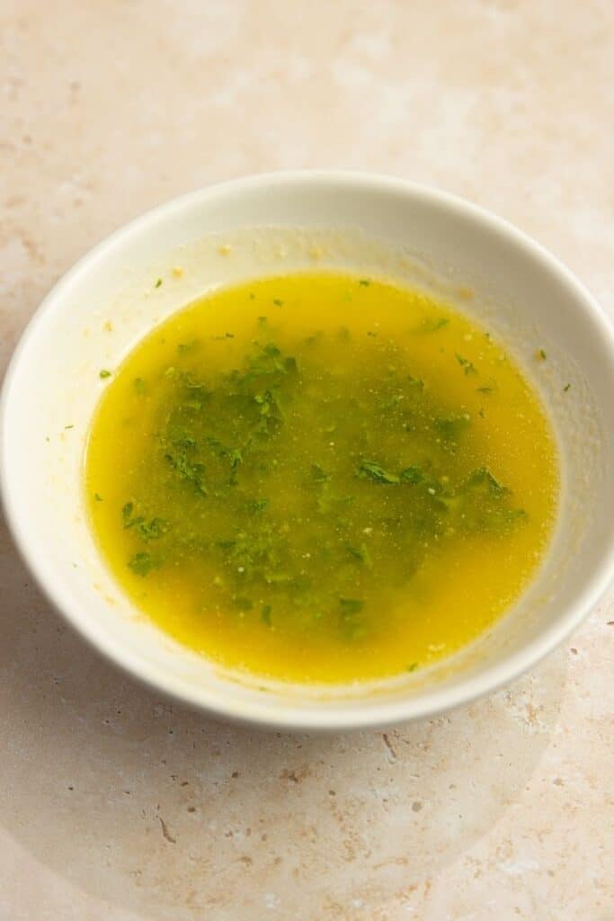 melted butter and parsley in a bowl.