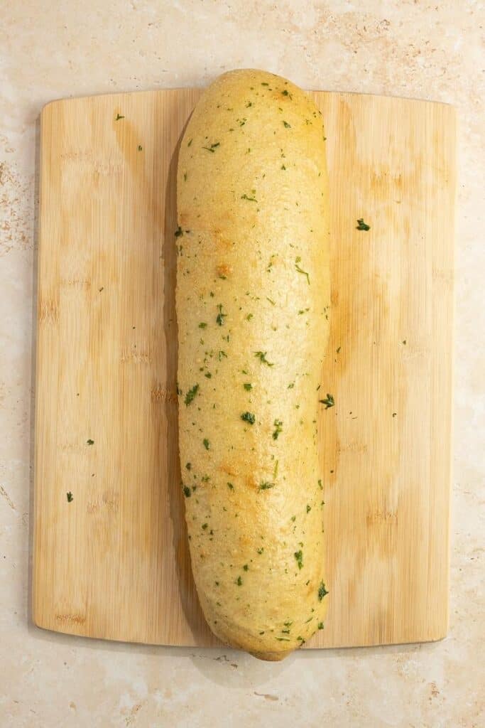 baked sourdough Stromboli on a wood cutting board.