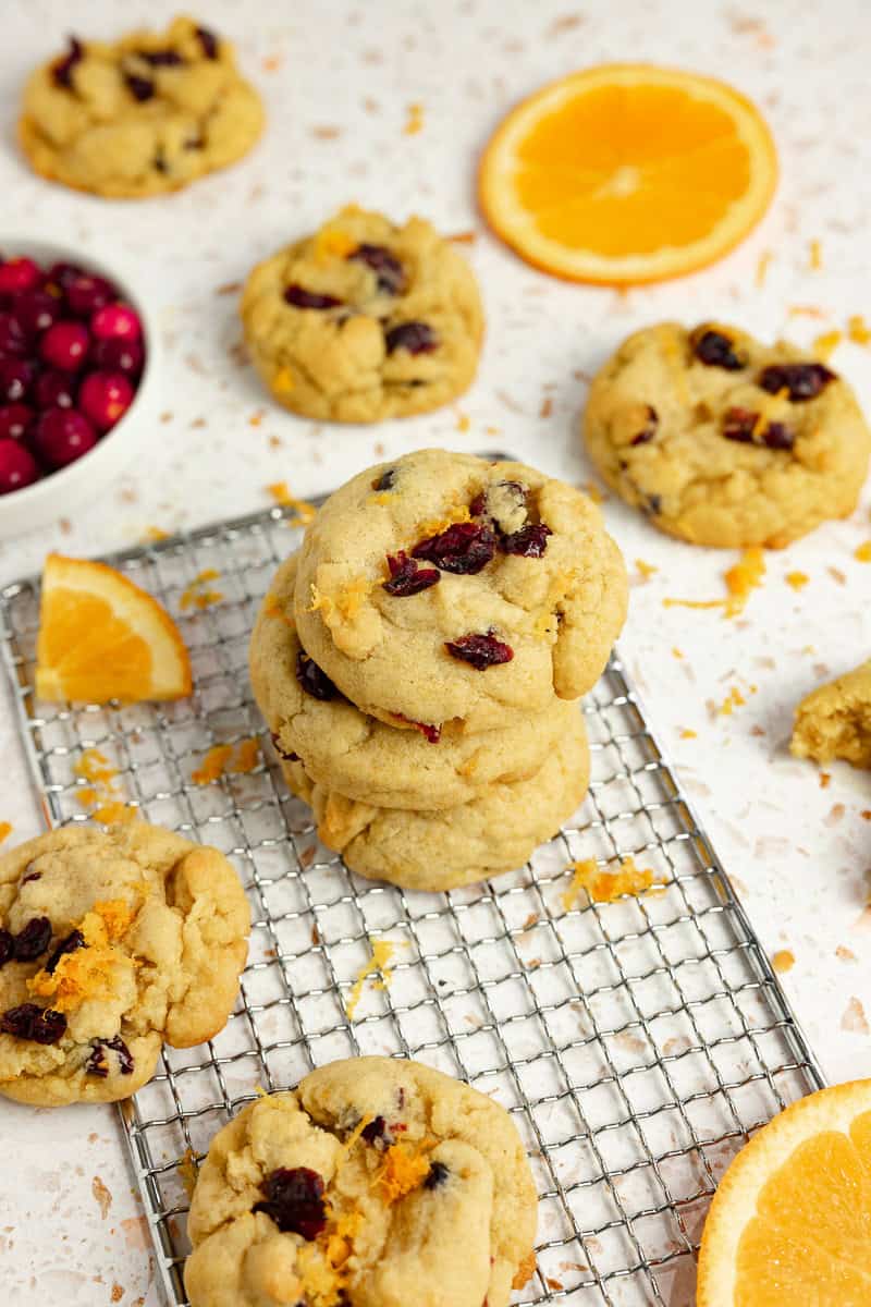 Cranberry cookies stacked on top of each other on a cooling rack.