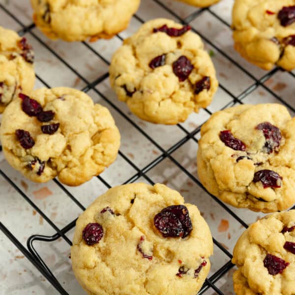 Cranberry orange cookies lined up on a cooling rack.