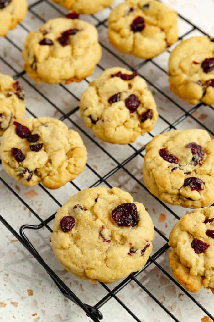 Cranberry orange cookies lined up on a cooling rack.