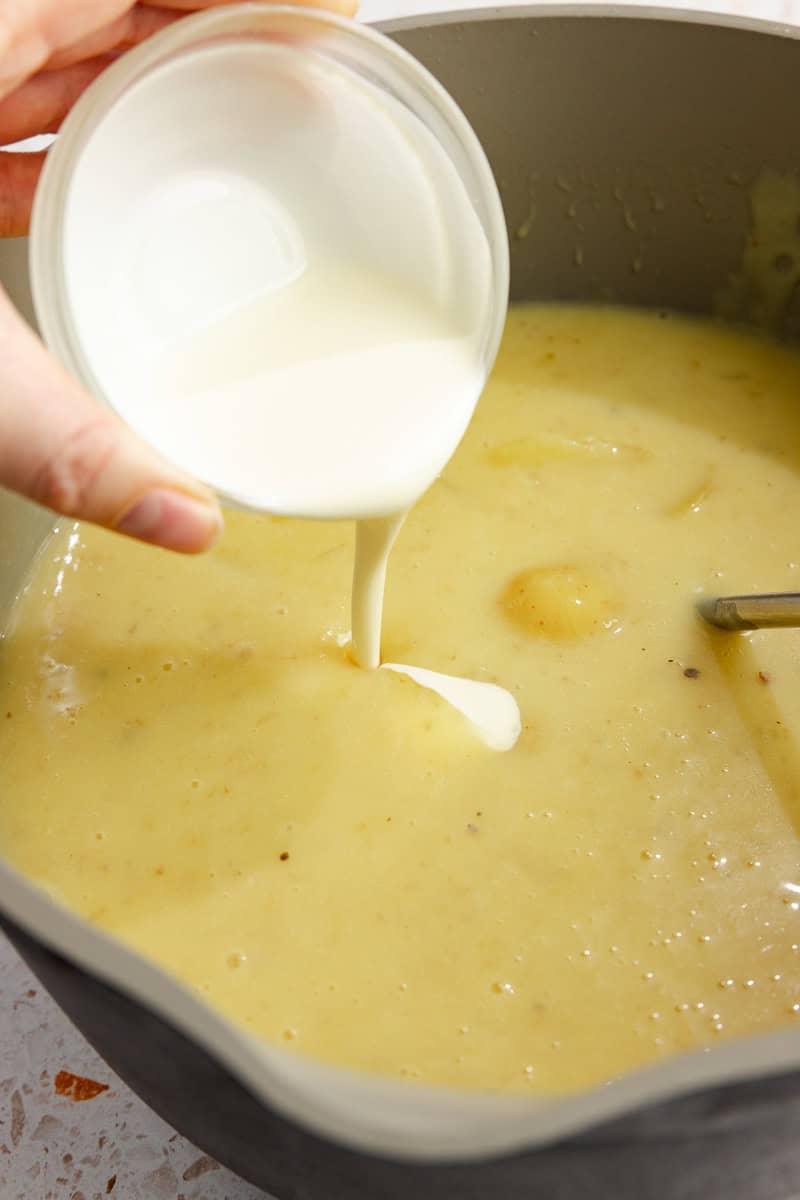 Poring cream into potato soups. 