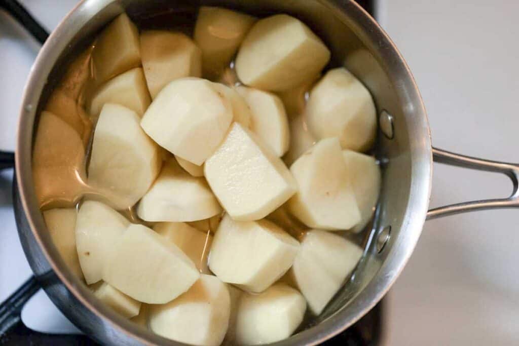 Peeled and chopped potatoes in a saucepan with water.