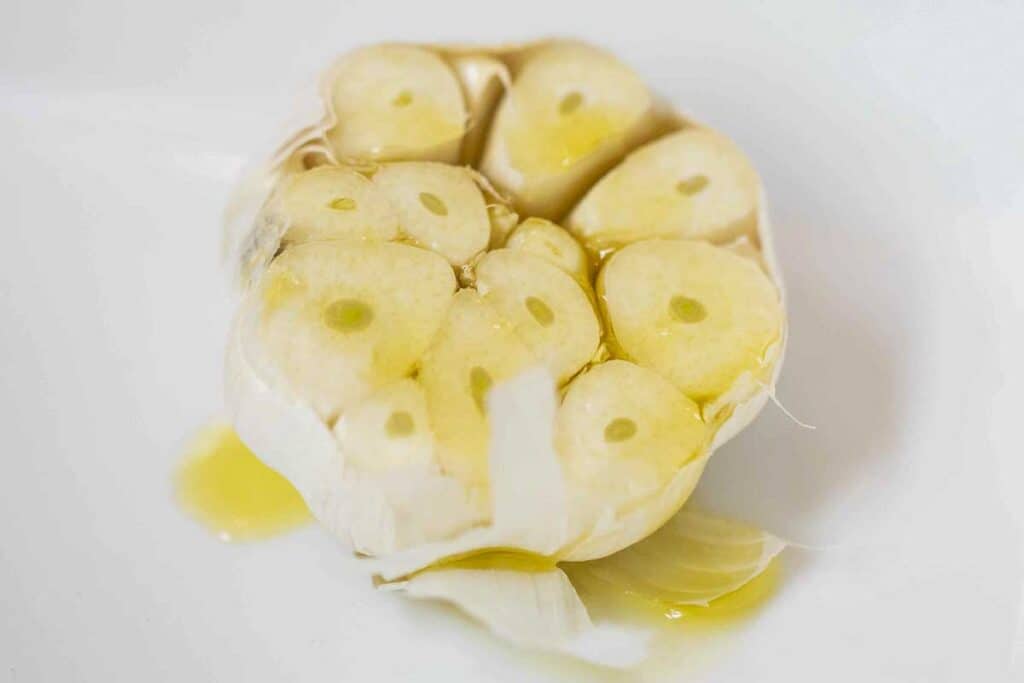 Head of garlic drizzled with olive oil.