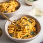 A bowl of pasta smothered in pumpkin sauce.