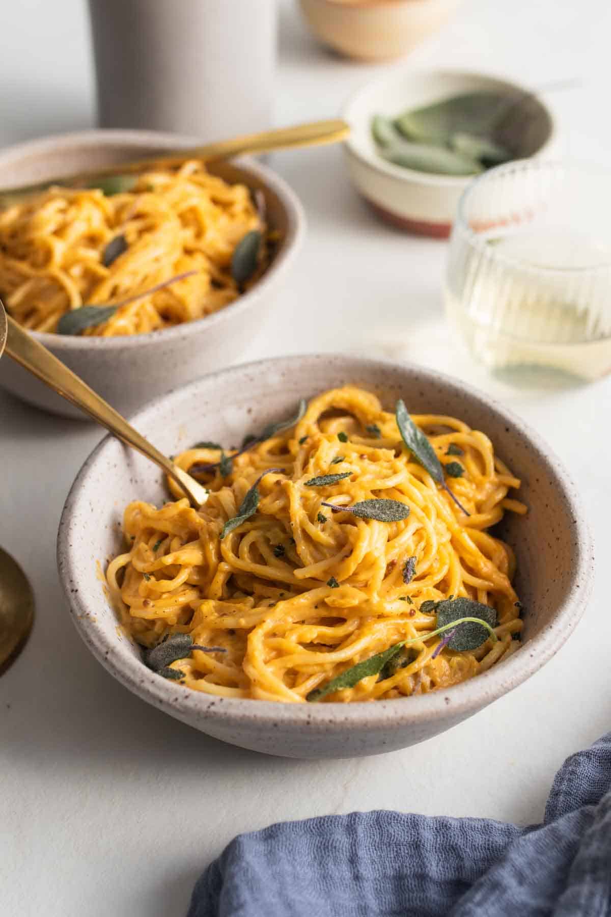 A bowl of pasta smothered in pumpkin sauce. 