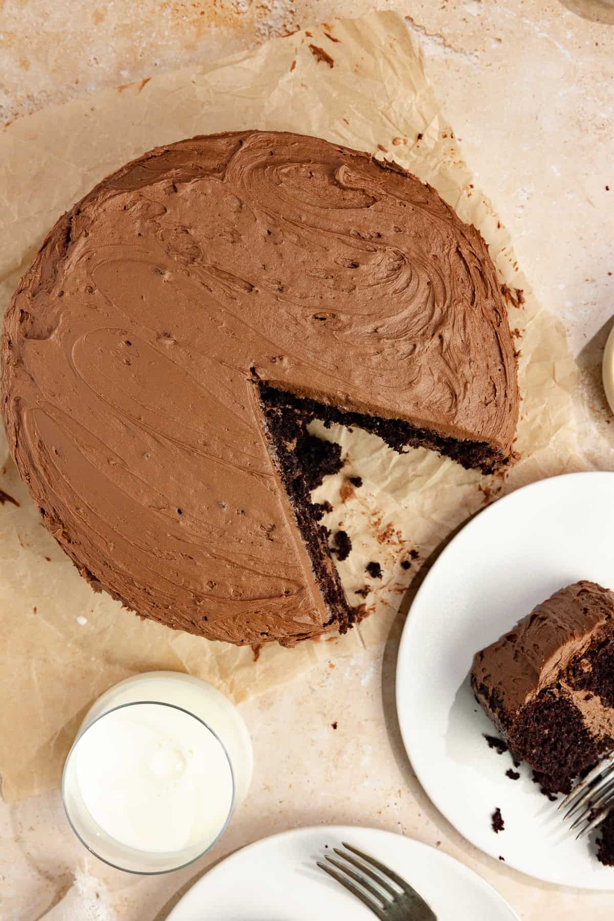 A whole cake with one slice missing and on a plate next to it.