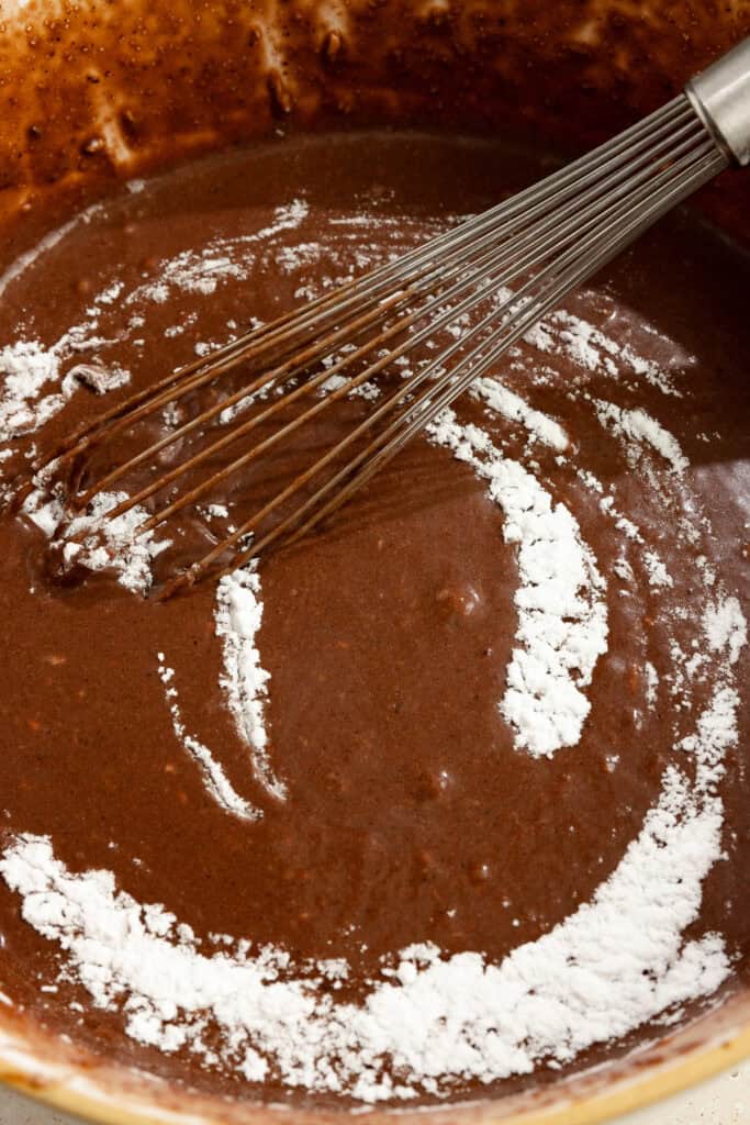 Chocolate cake batter in a bowl with a whisk.