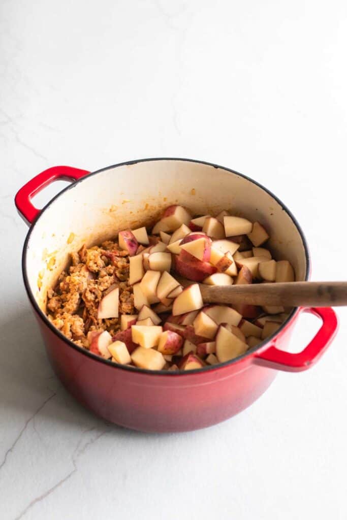 Diced potatoes added to a large dutch oven.