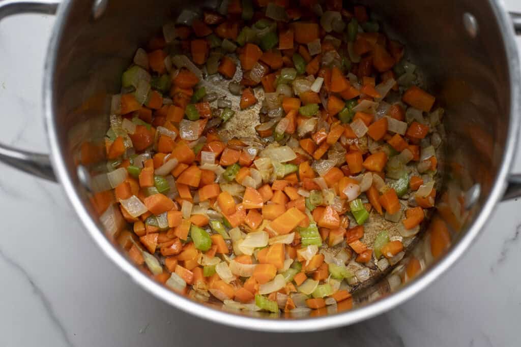 Diced vegetables cooked down in a large stock pot.