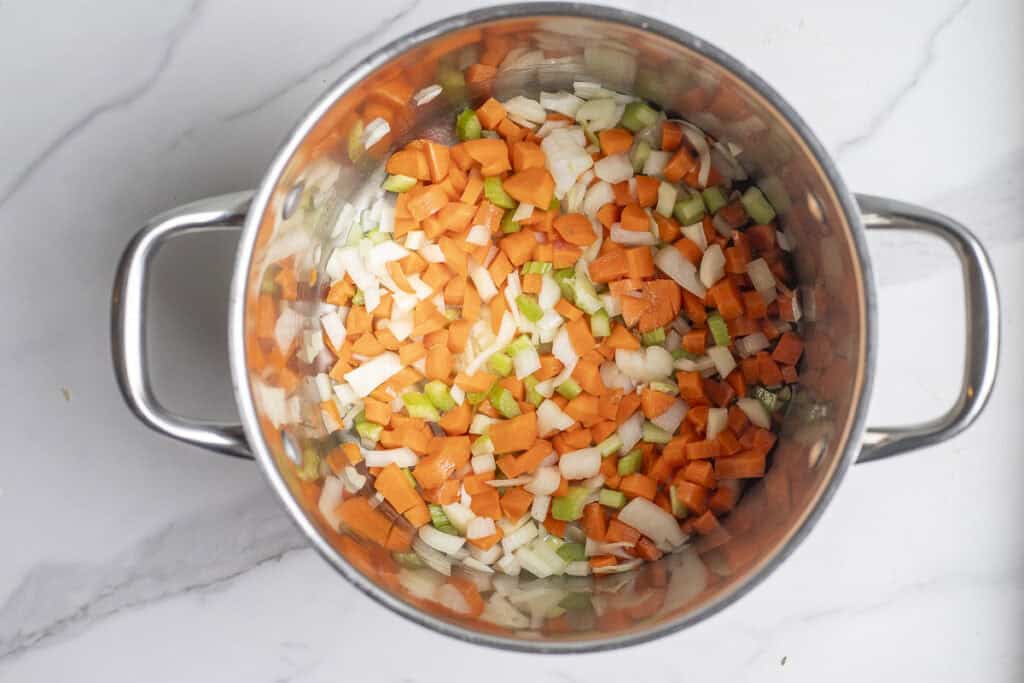 Onion, carrots, and celery diced and cooking in a large stock pot. 