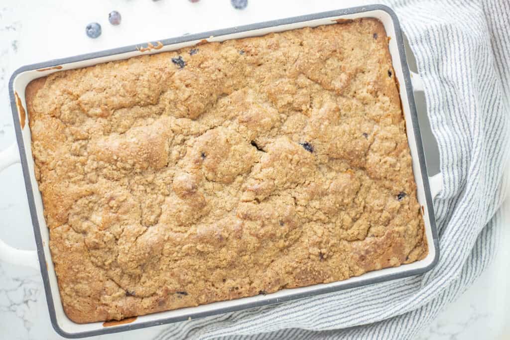 Baked sourdough blueberry coffee cake in a baking dish.