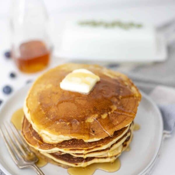 A stack of sourdough discard pancakes with a slab of butter on top.