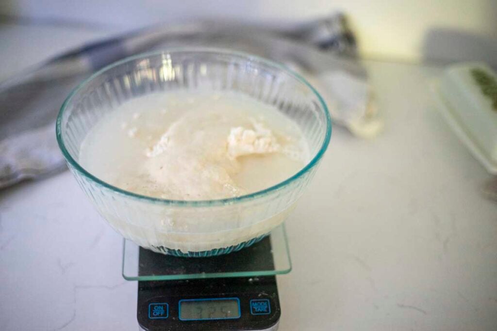 Weighing, flour, water, sourdough starter, and salt in a bowl.