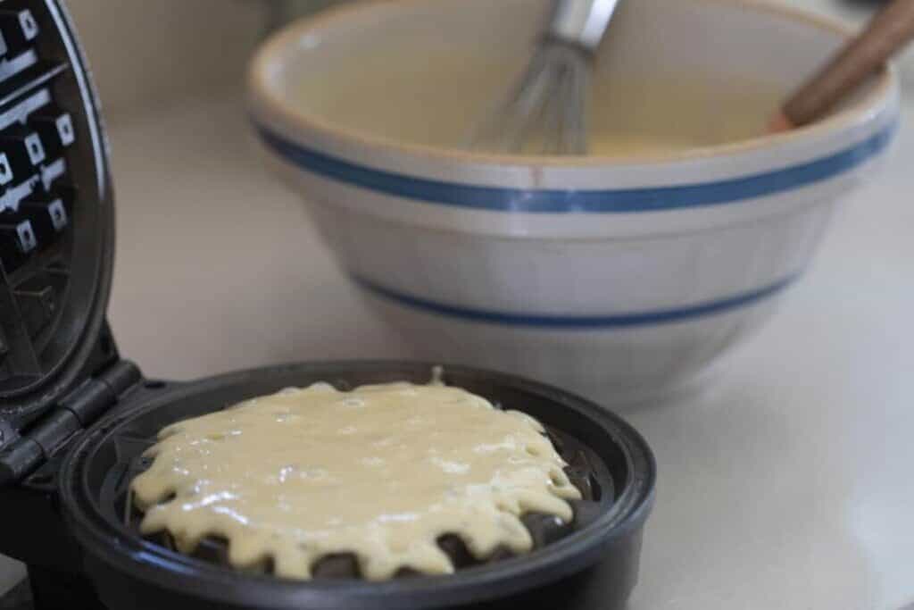 Waffle batter poured into a waffle maker.