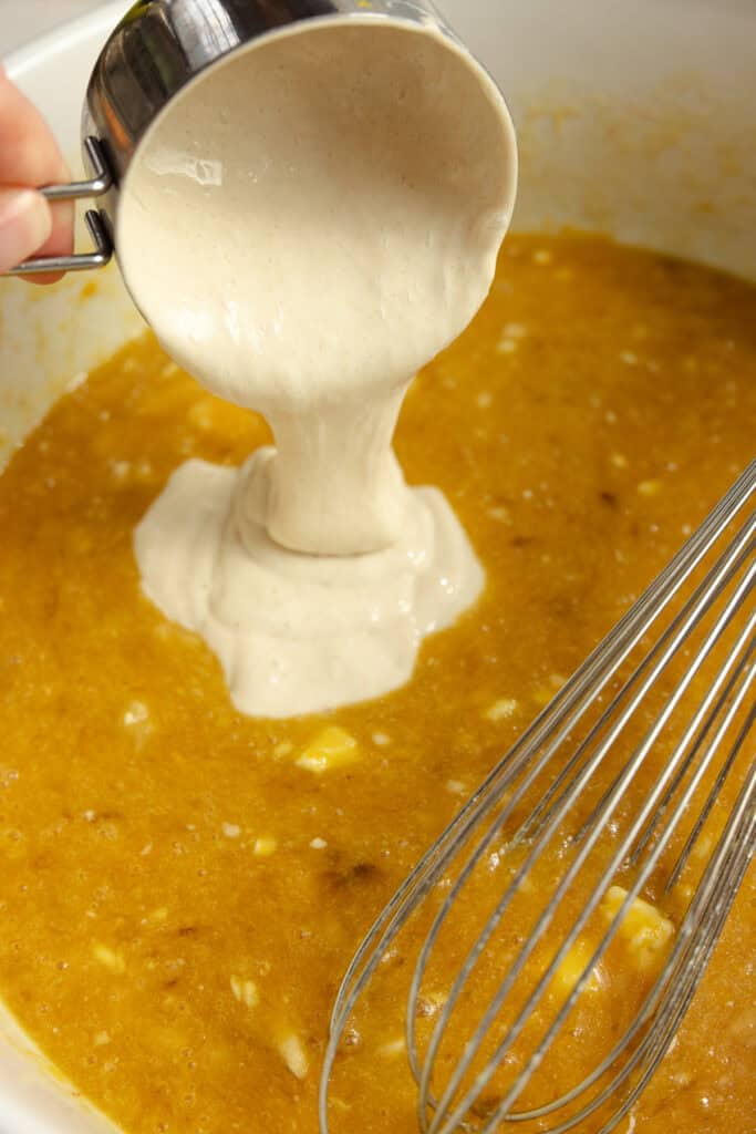 Sourdough starter added to wet ingredients bowl.