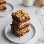 Two date squares on top of each other on a white plate.