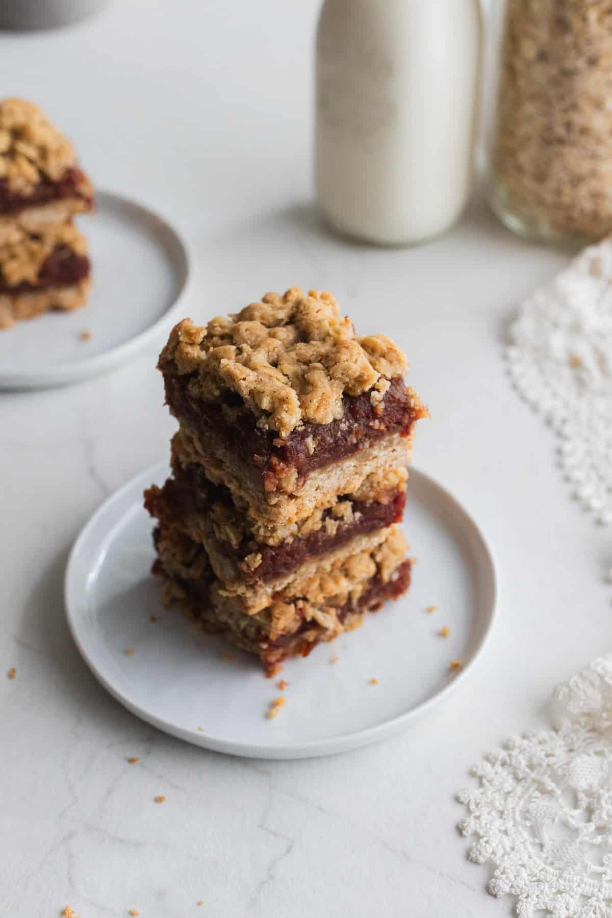 Two date squares on top of each other on a white plate.