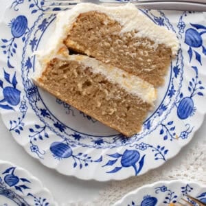 A slice of earl grey cake with cream cheese frosting on a blue floral plate.