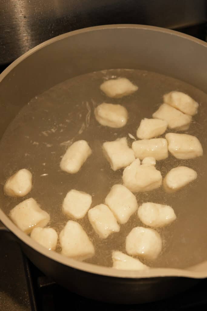 A large pot of boiling water with gnocchi cooking.