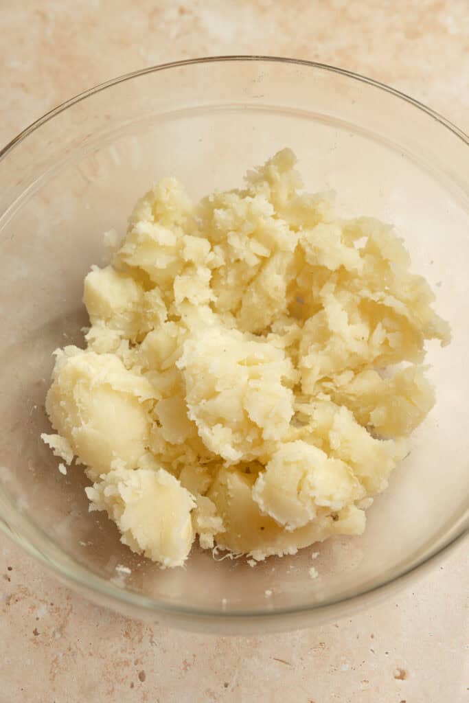 Cooked baked potato in a bowl with skin removed.