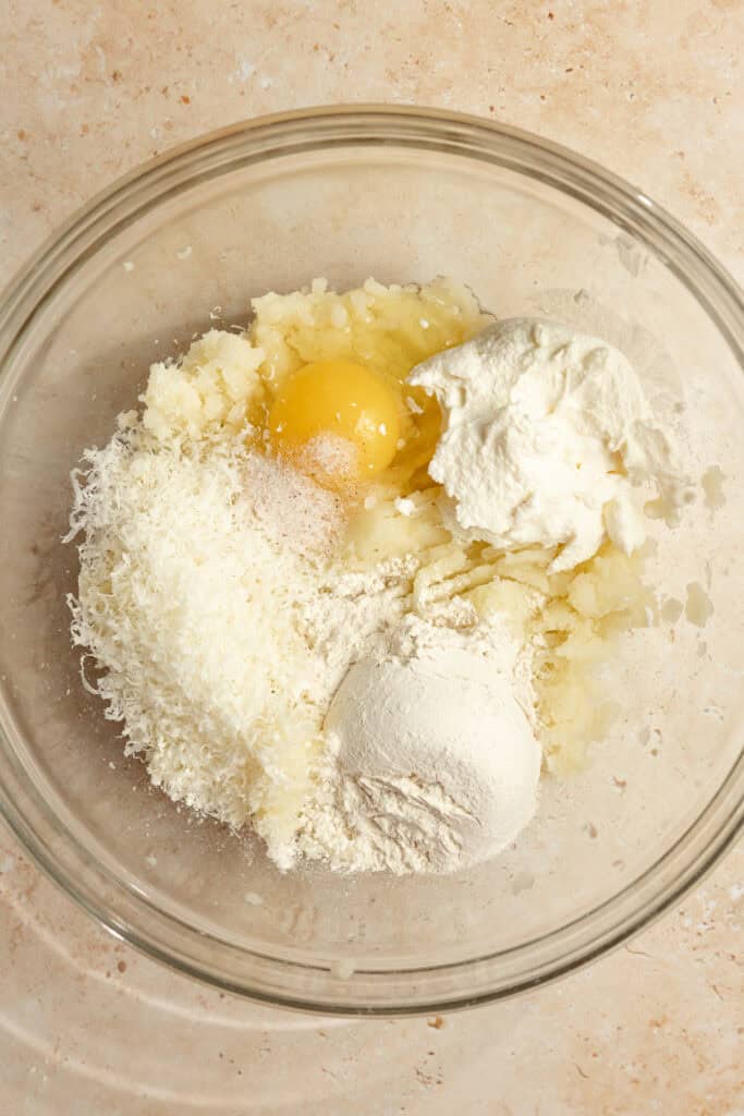 An egg and other ingredients added to mashed potatos.