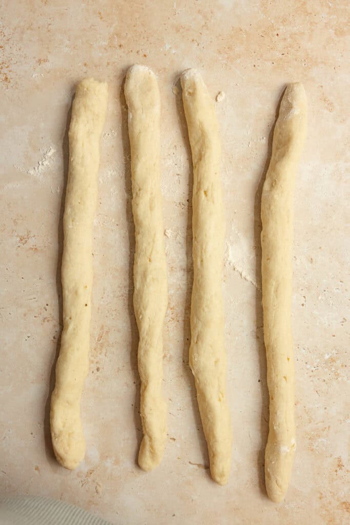 Dough rolled out into four long strips of dough.