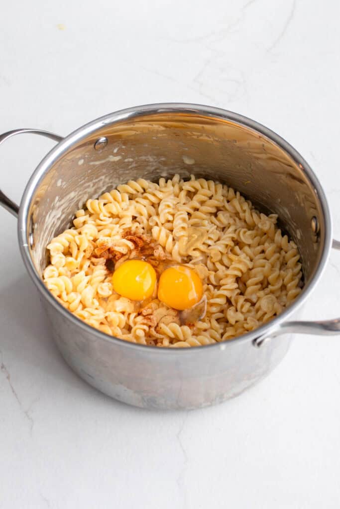 Eggs added to a pot of pasta.