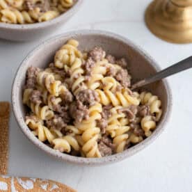 A bowl of hamburger helper with a spoon sticking out.