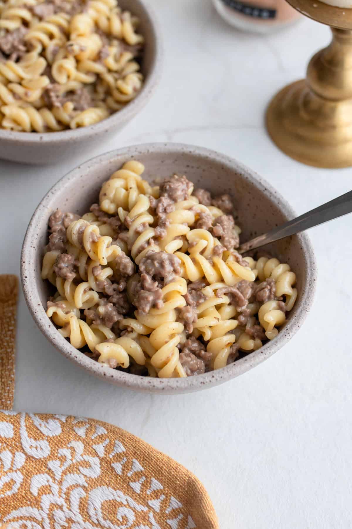 A bowl of hamburger helper with a spoon sticking out.