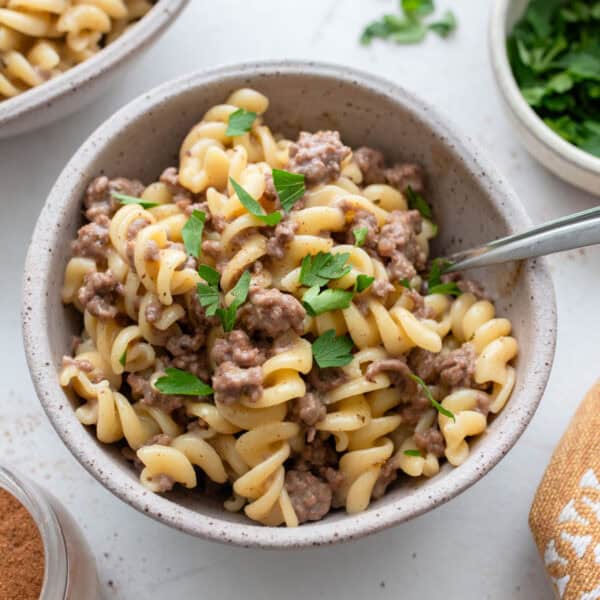 A bowl of hamburger helper garnished with herbs.