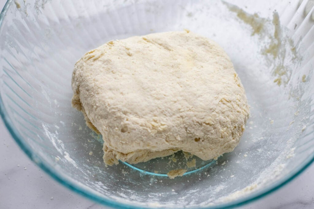 A dough ball in a glass bowl. 