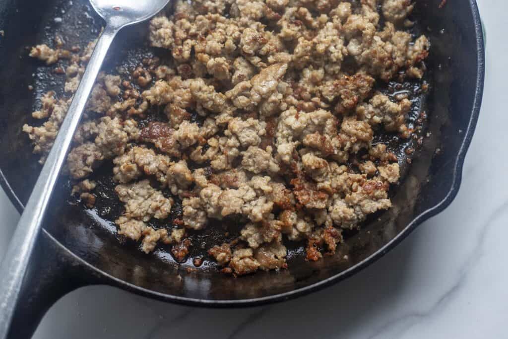 Browning meat in a cast iron skillet.