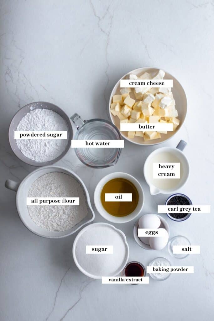 flour, butter, tea, sugar, and other ingredients in bowls on a countertop.