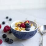 A bowl of yogurt with a spoon laying next to it.