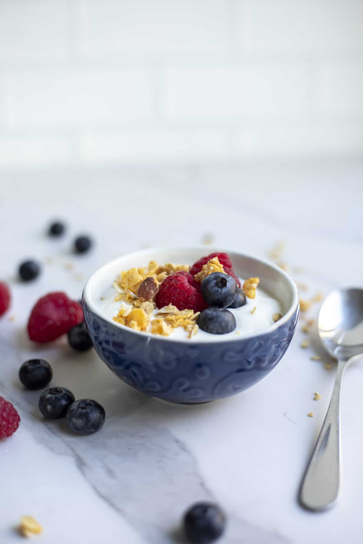 A bowl of yogurt with a spoon laying next to it. 