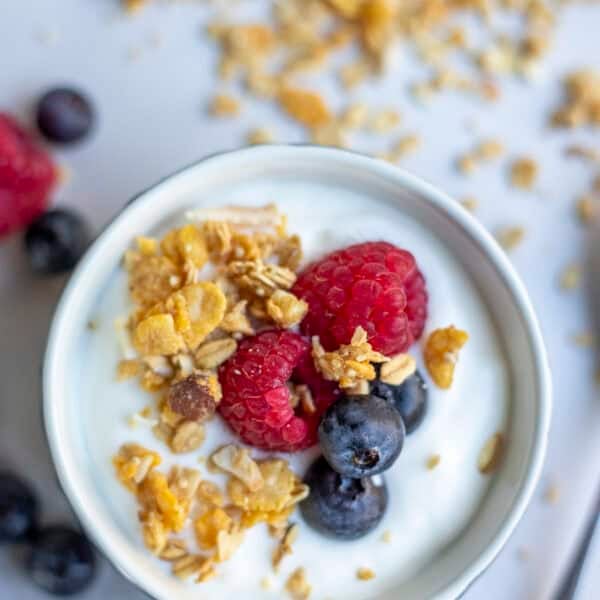 A bowl of yogurt topped with granola and fruit.