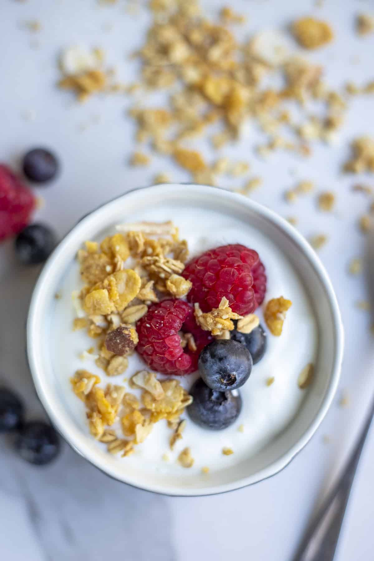 A bowl of yogurt topped with granola and fruit.