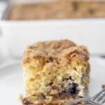 close up picture of sourdough blueberry coffee cake on a plate with a fork.