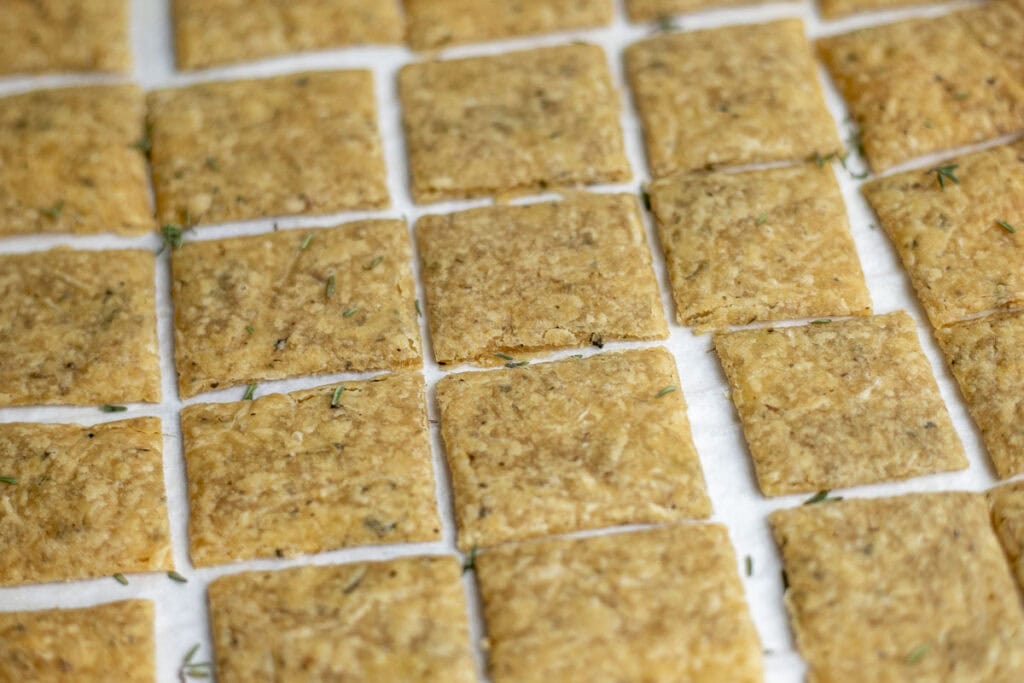 Baked sourdough crackers on parchment paper.