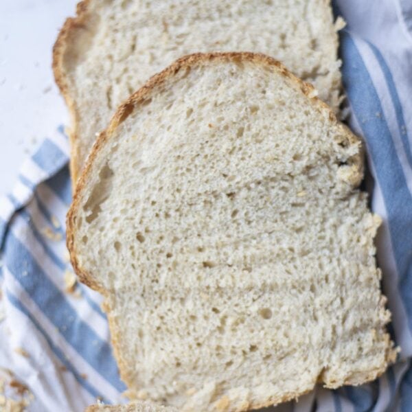 overhead photo of two slices of sourdough oatmeal bread laying on a towel.