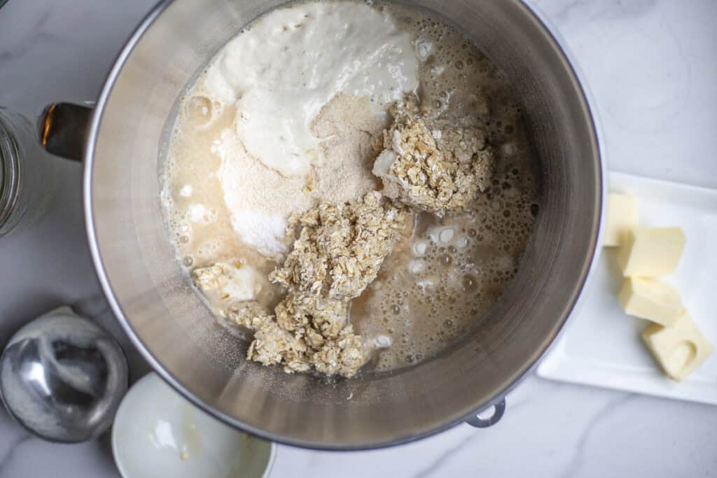 flour, soaked oatmeal, water, sourdough starter, sat, in a stand mixer bowl.