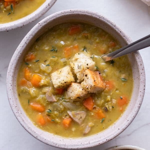 A bowl of soup with croutons on top.