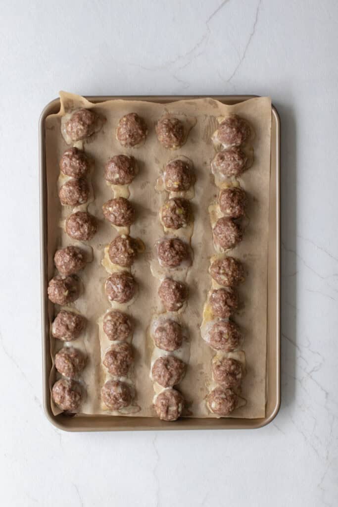 Cooked meatballs on a baking sheet.