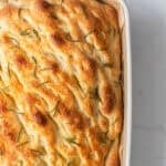 Baked sourdough focaccia in a baking dish.