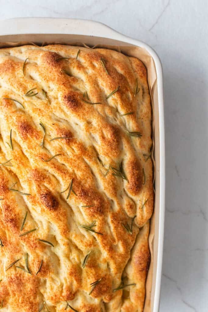 Baked sourdough focaccia in a baking dish. 