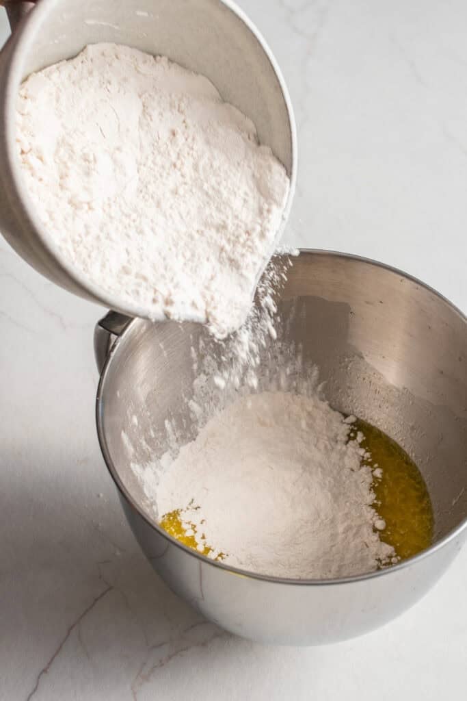 Flour added to a stand mixer bowl. 